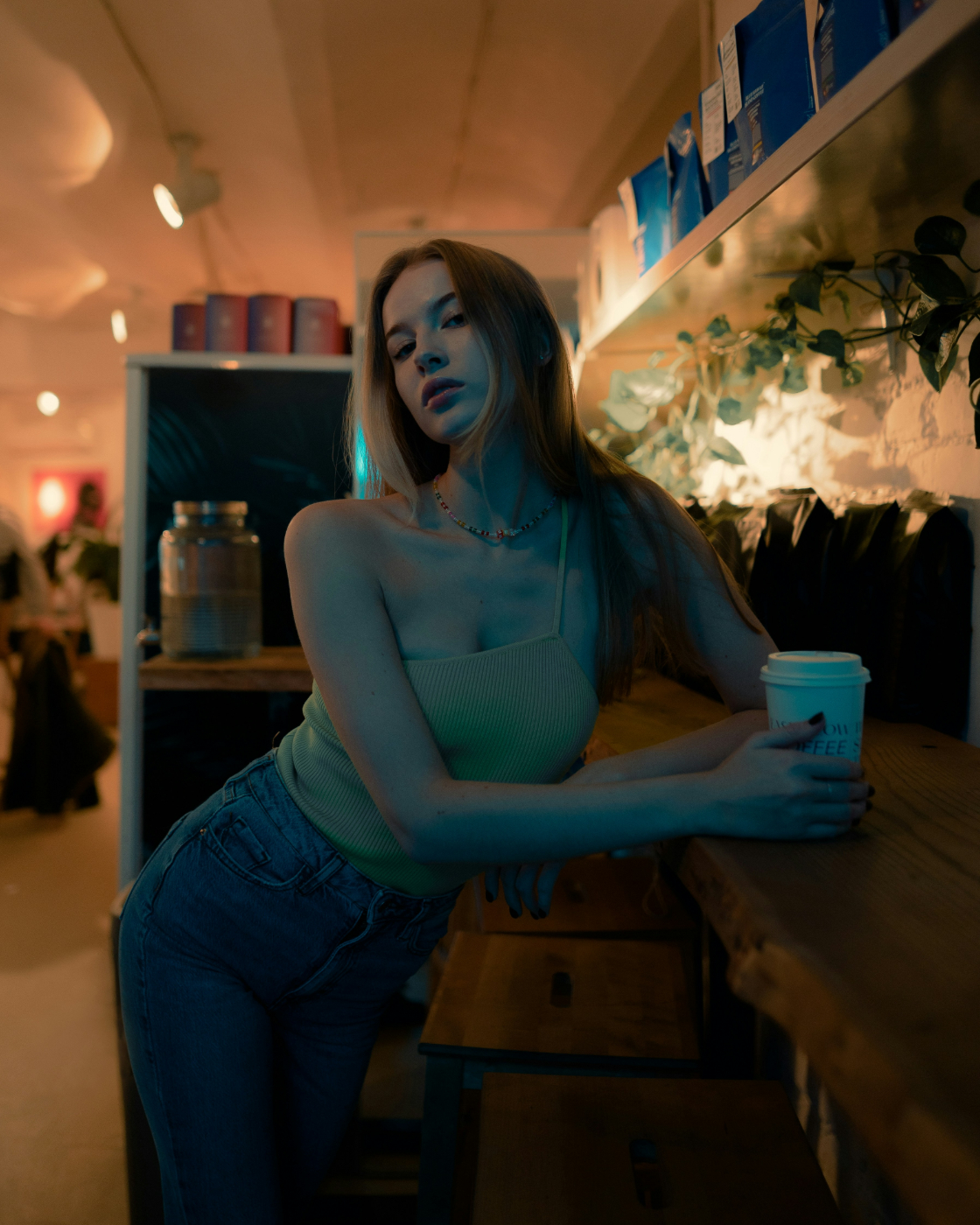 A lovely woman leaning on a counter in a coffee shop