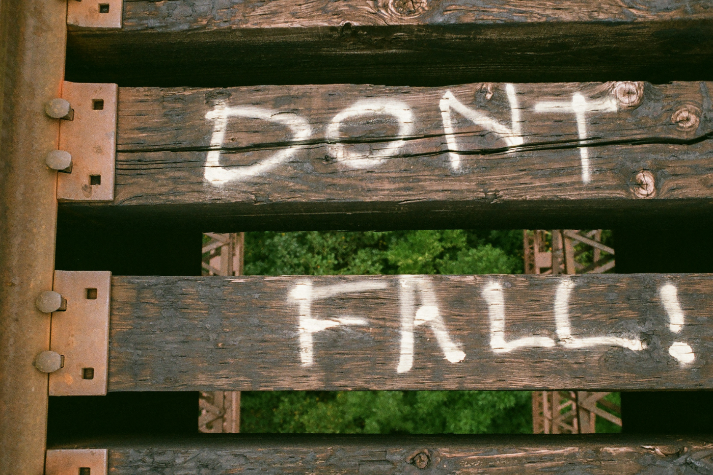 A raised railway with don't fall painted on the ties