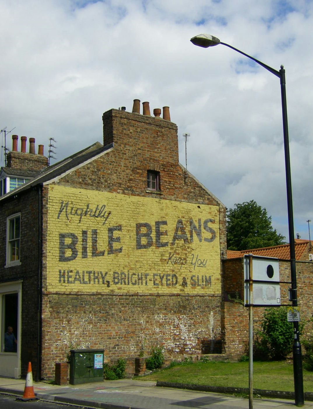 an ad on the side of a brick building for Bile Beans