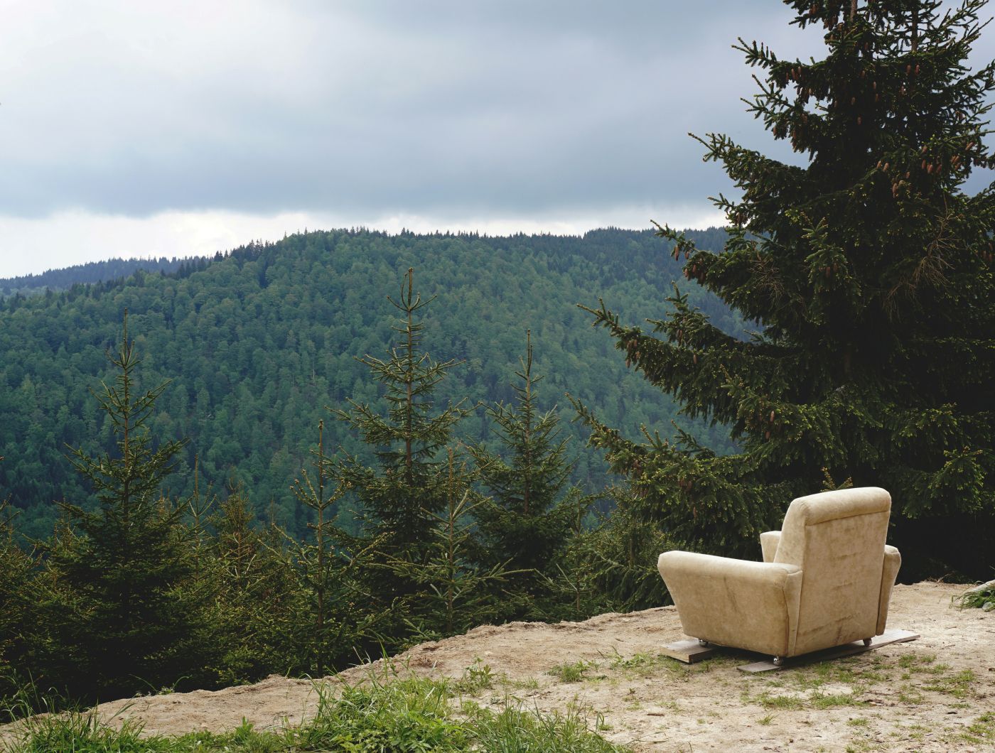 An easy chair on a the edge of a cliff overlooking a beautiful valley