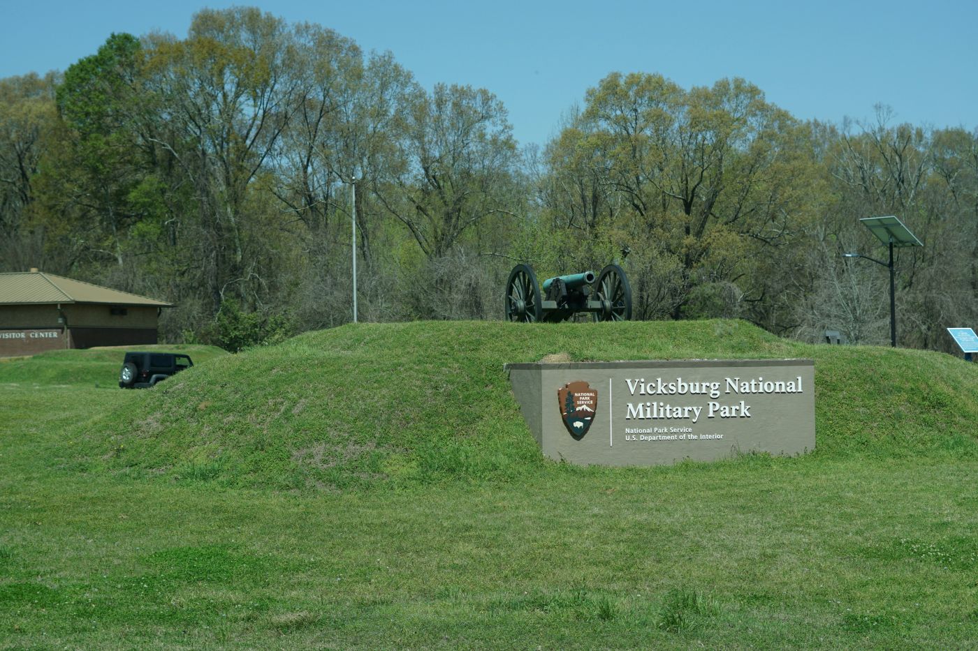 A cannon overlooking a sign reading Vicksburg National Military Park