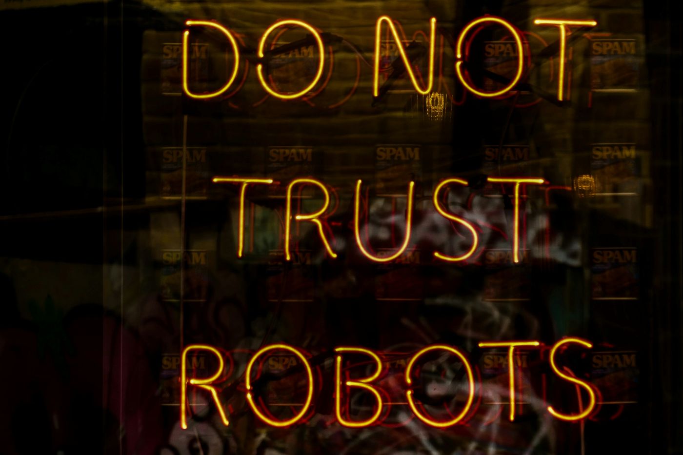 A yellow neon sign reading Do Not Trust Robots