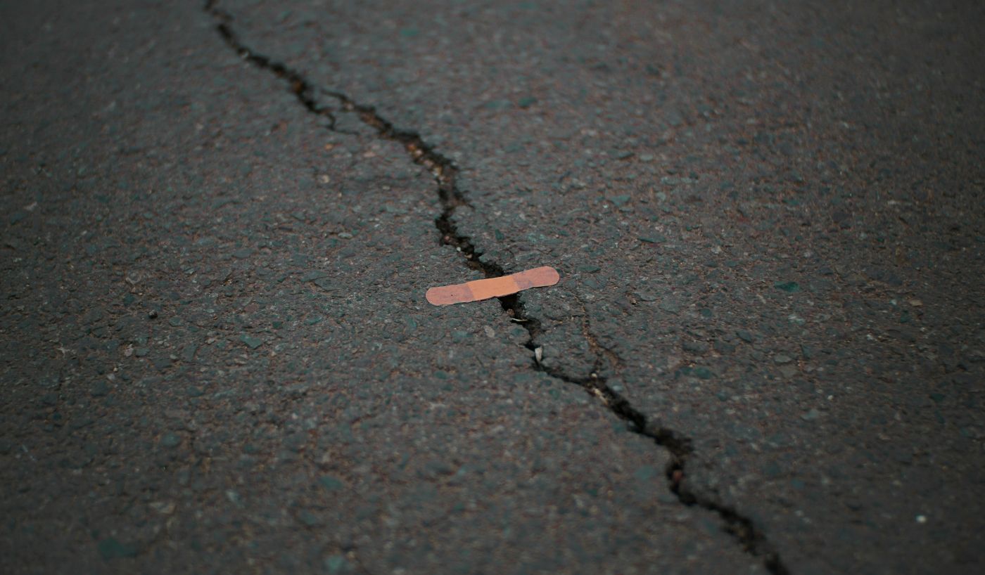 A crack in asphalt "fixed" with a band aid