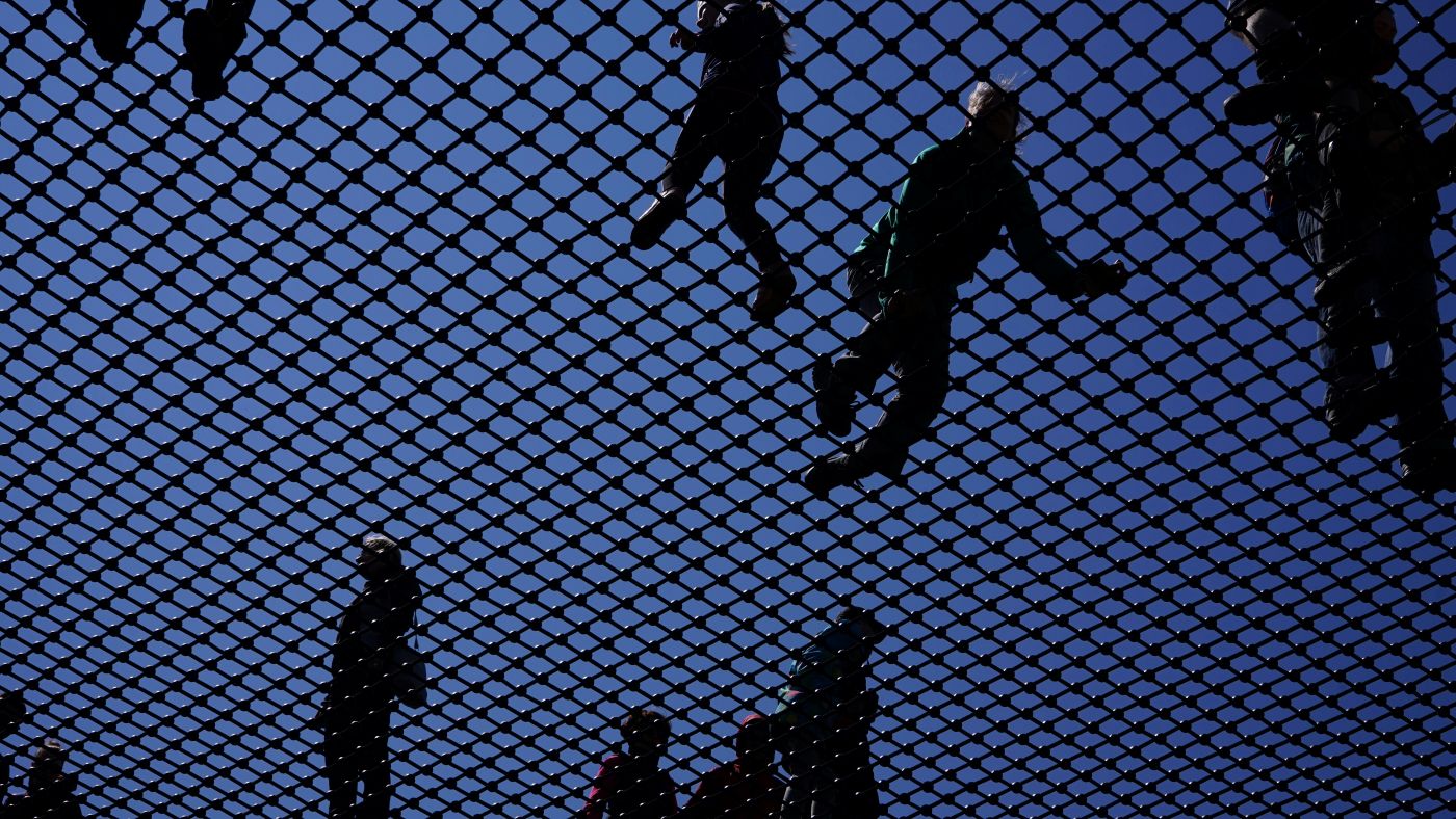 People walking on a mesh screen in daylight