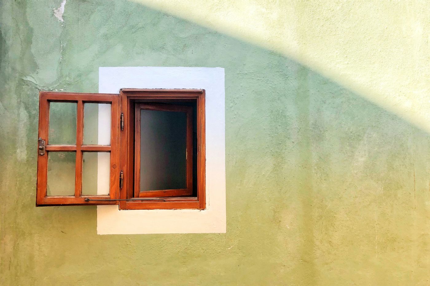A small brown open window in a wall