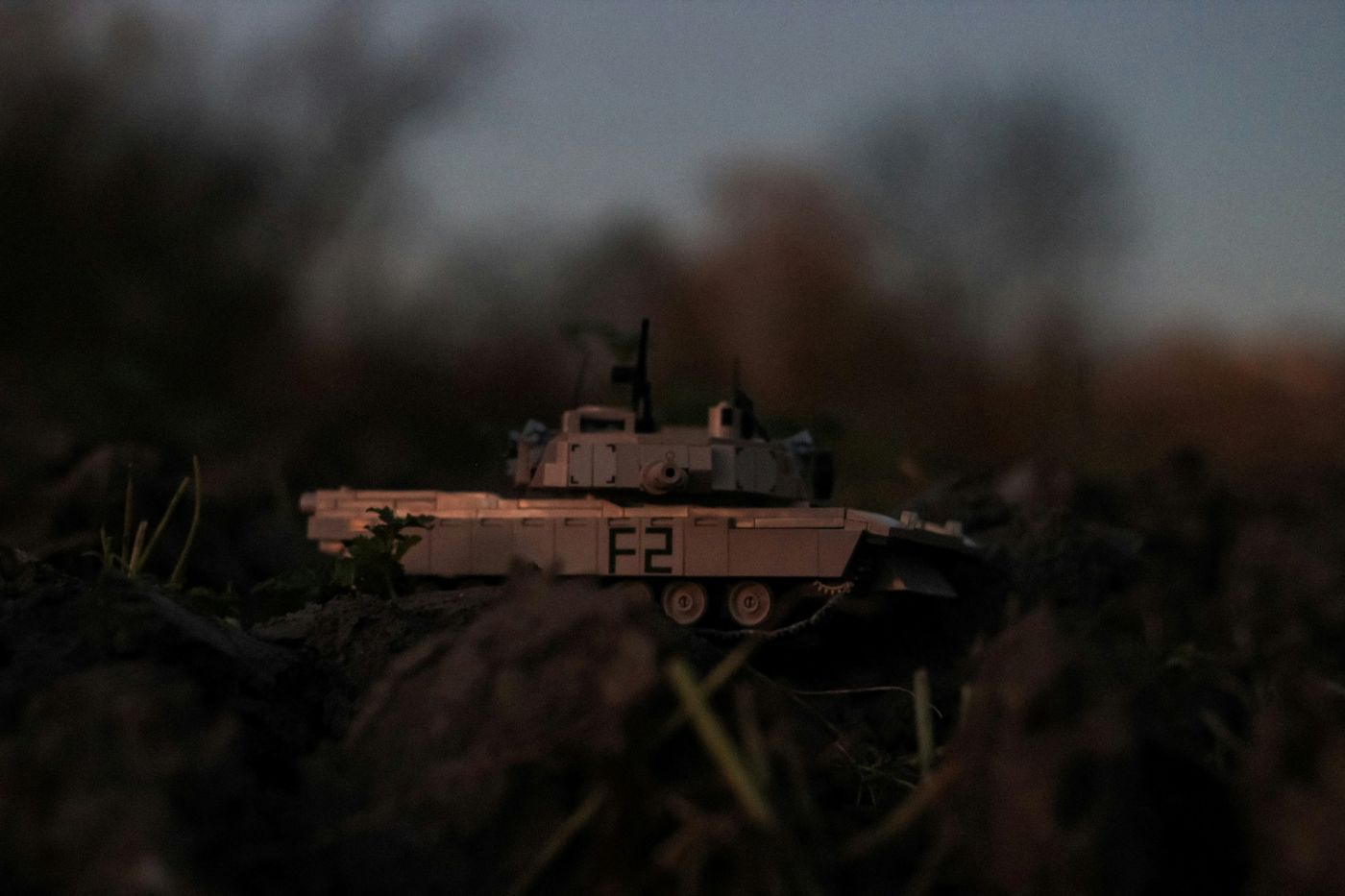 A toy tank on a pile of dirt