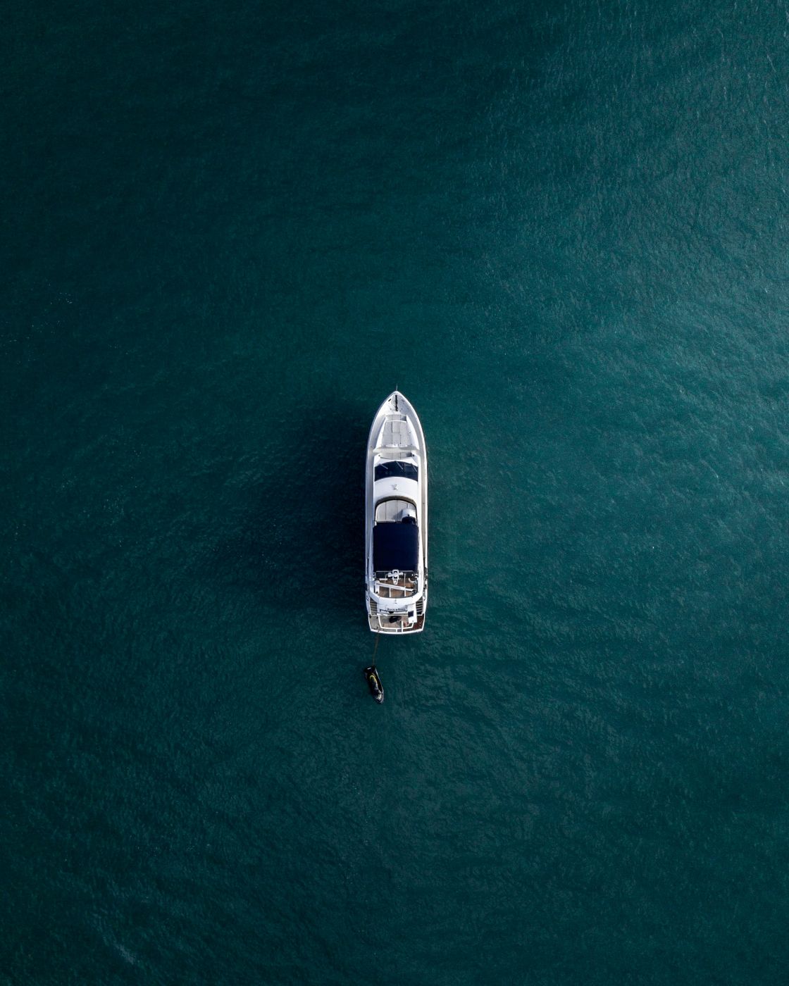 Arial shot of a white yacht on calm blue water