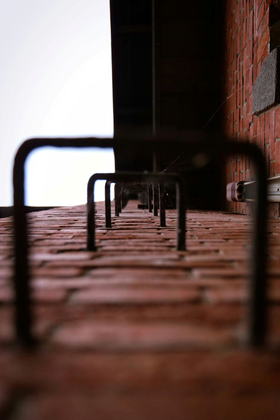 Black metal ladder rungs on a brick wall