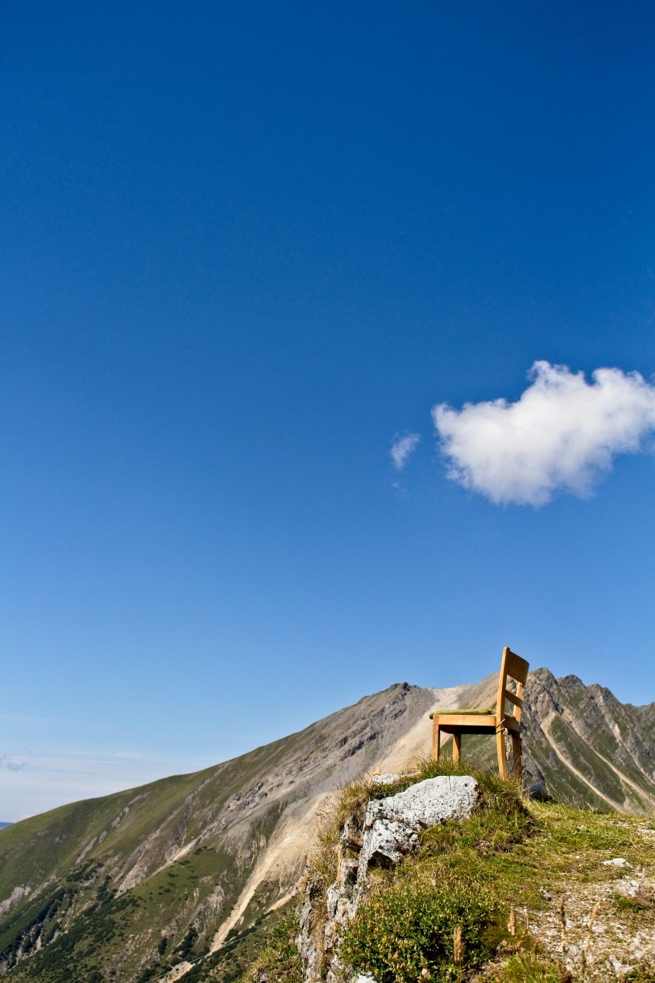 A single wooden chair on the top of a hill