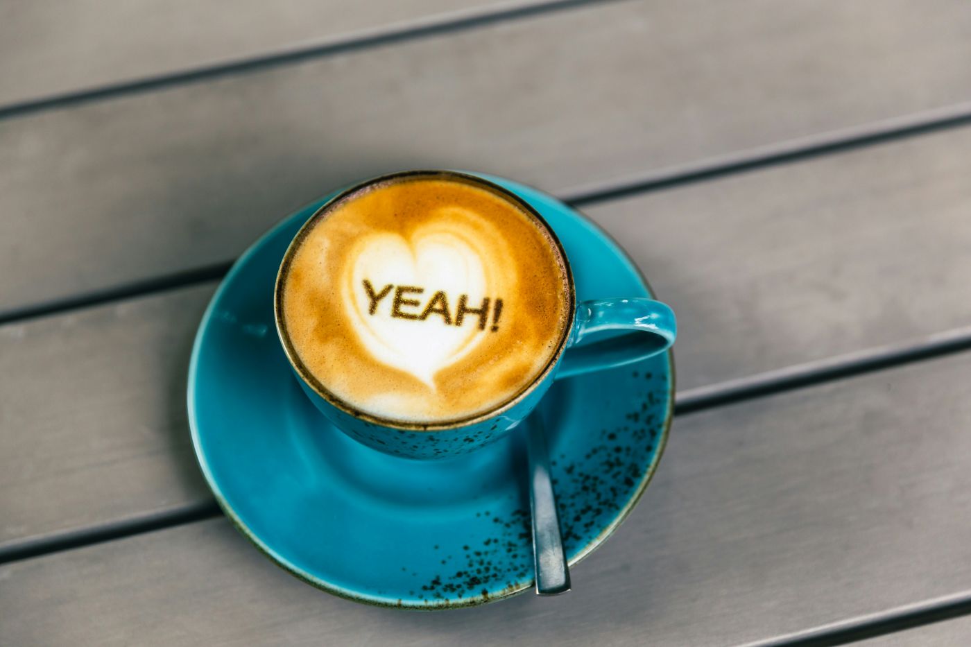 Blue coffee cup, the word yeah written in the foam