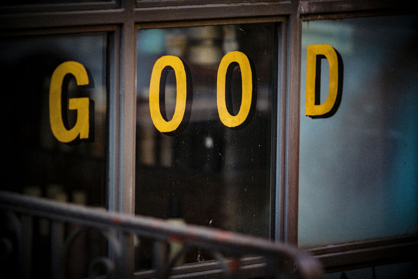 A shop window with GOOD painted on it