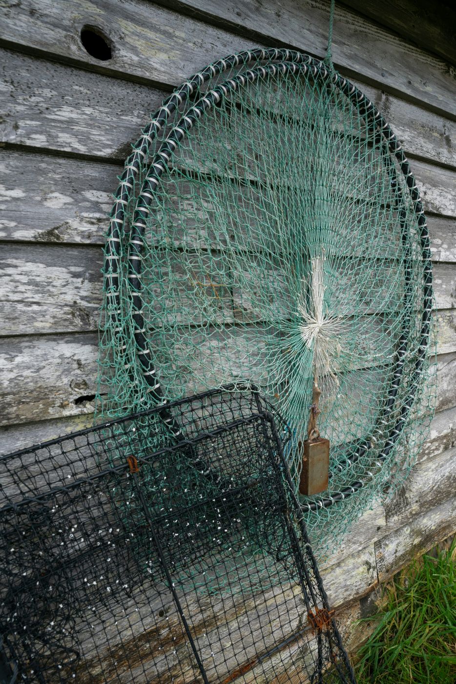Fishing nets leaning against a wood wall
