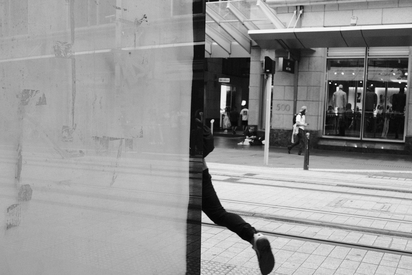A person disappearing behind a building