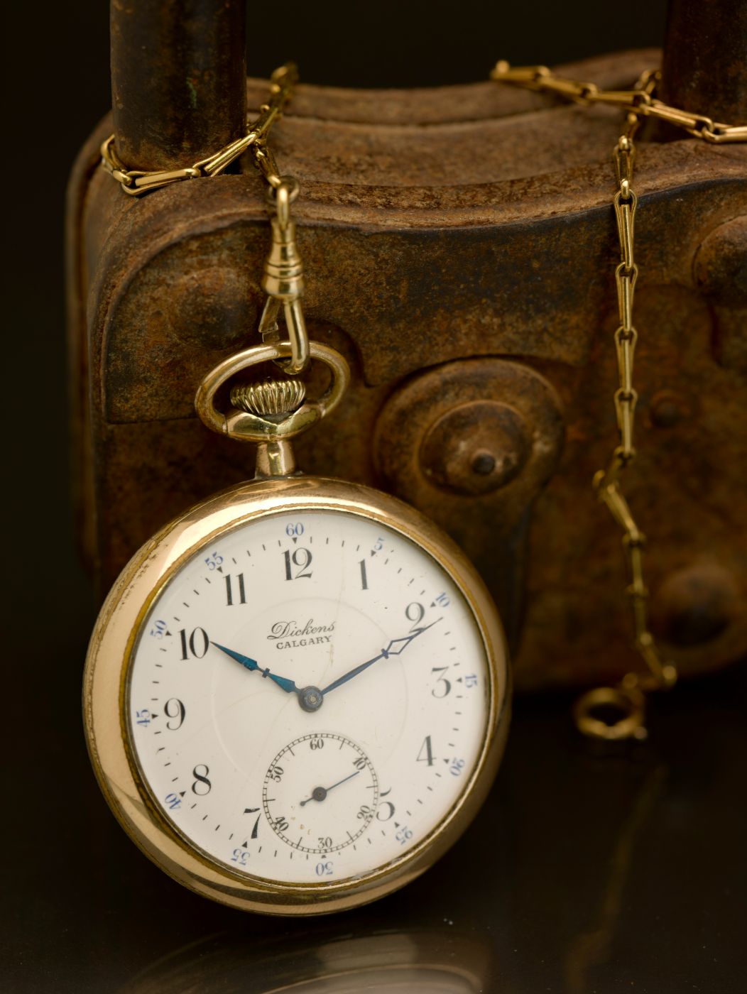 A gold pocket watch showing ten after ten