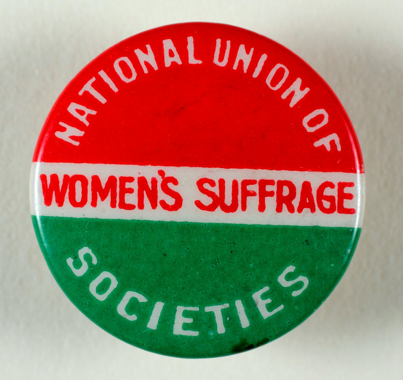A red, white and green Women's Suffrage button