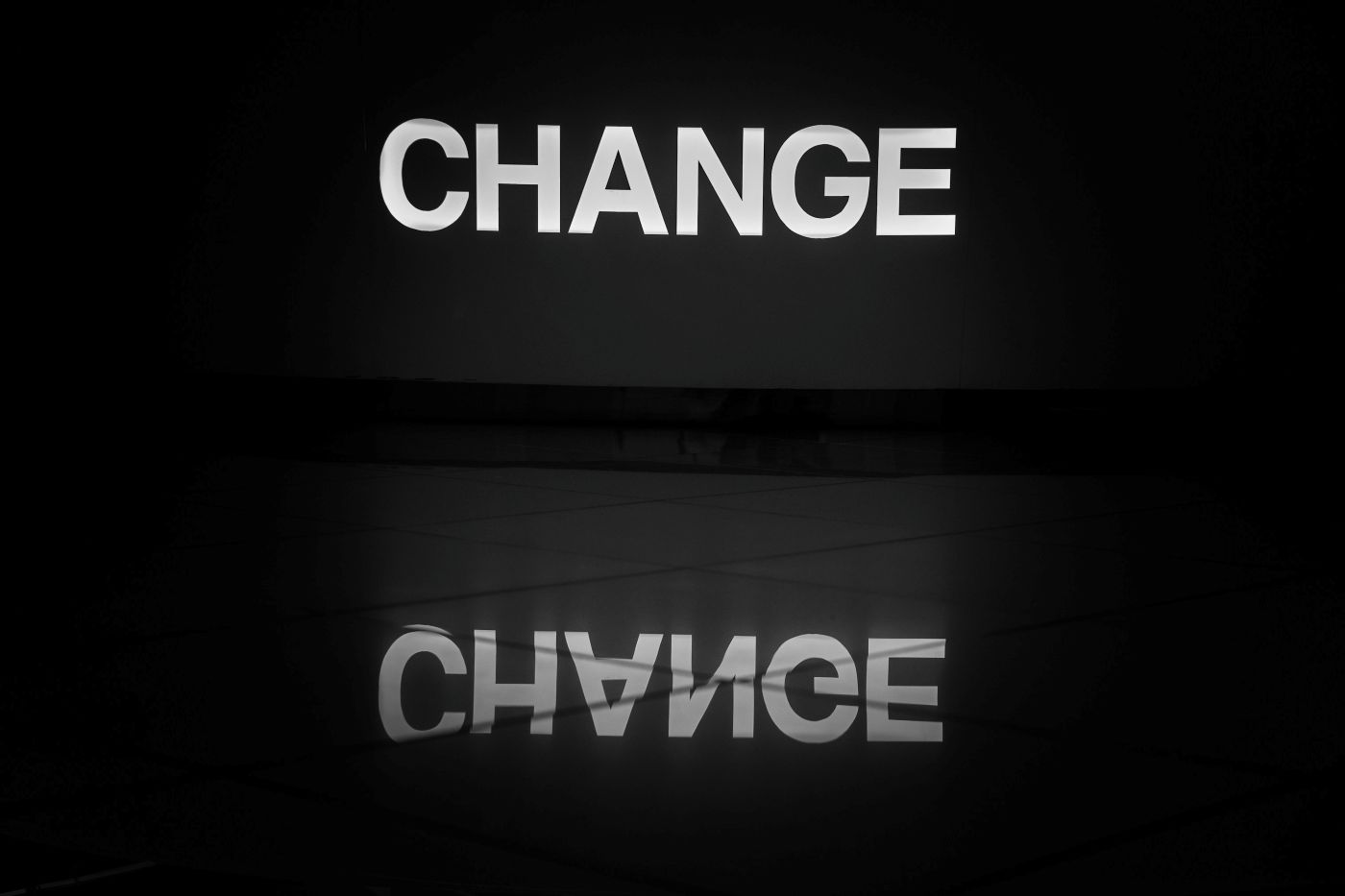 The word change on a wall reflected in a polished floor