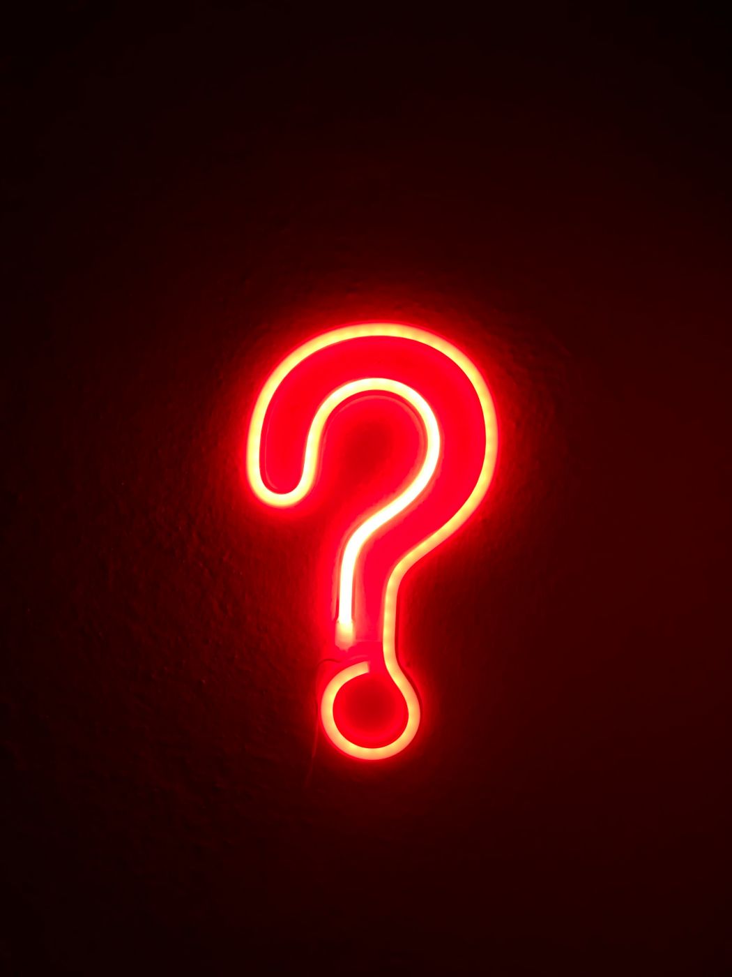 A red neon question mark