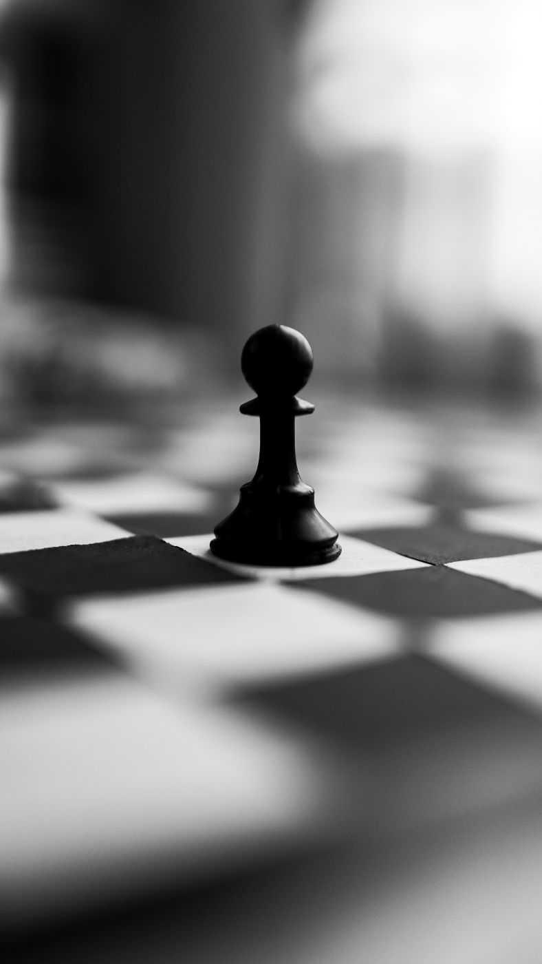 a single pawn on a black and white board