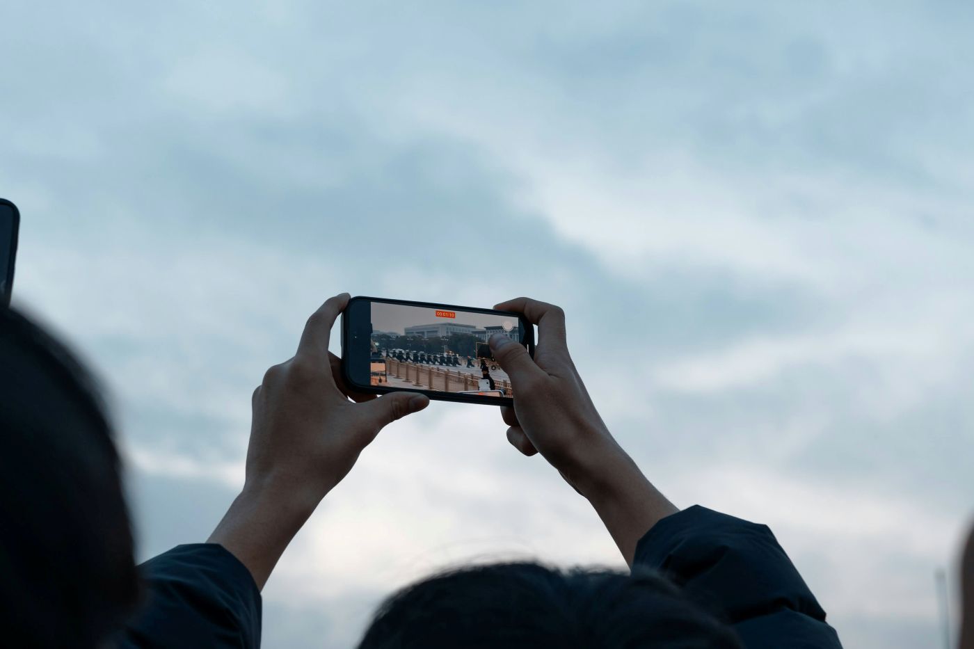 A person holding their phone over their head and filming