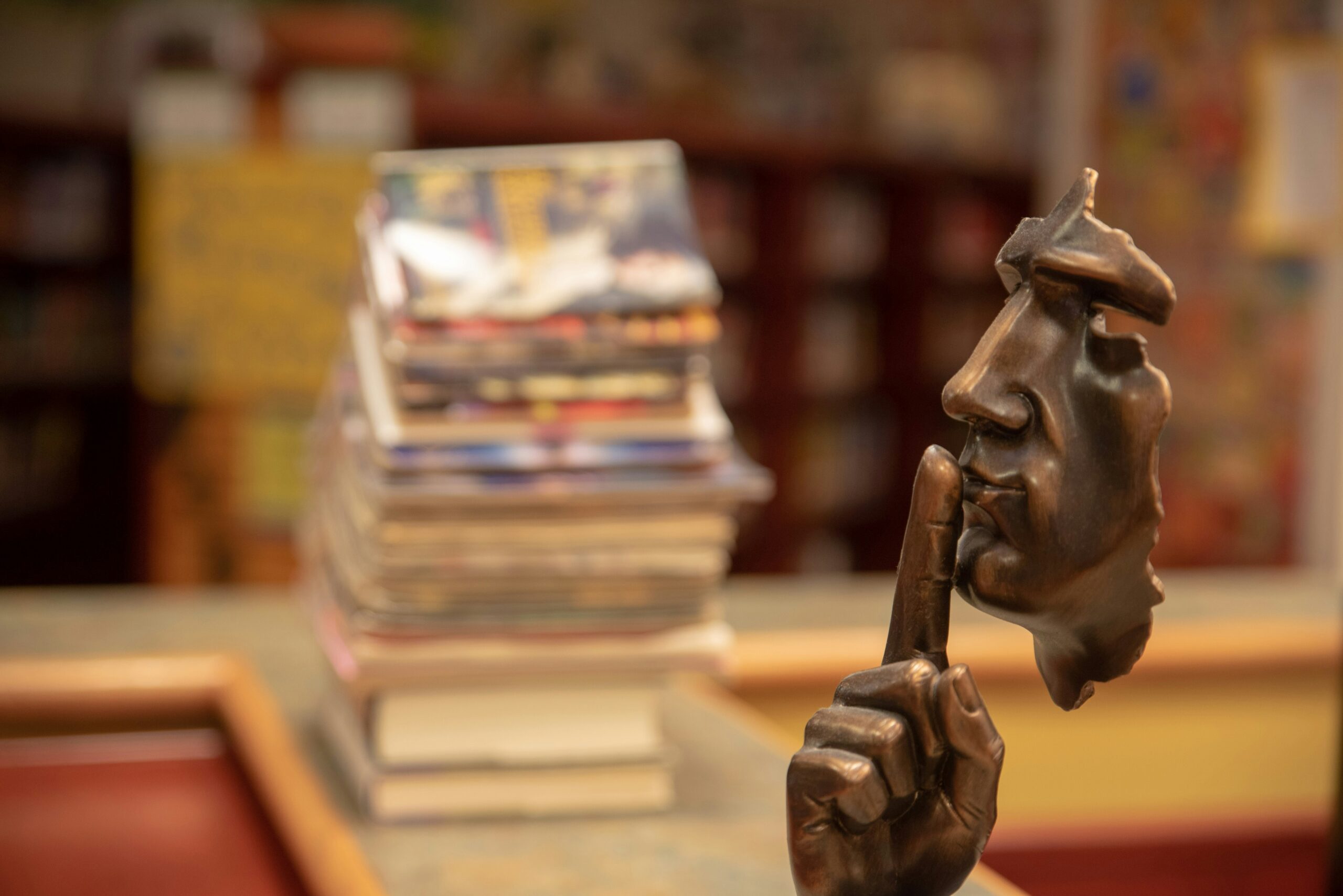 A statue of half a human face with a finger to it's lips