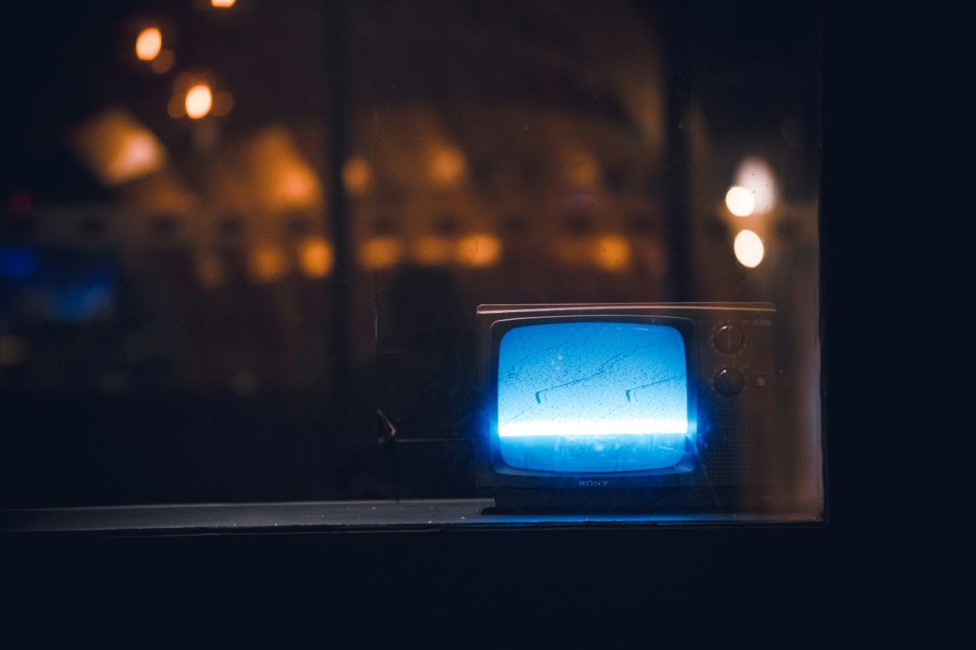 a small TV in a window showing blue light