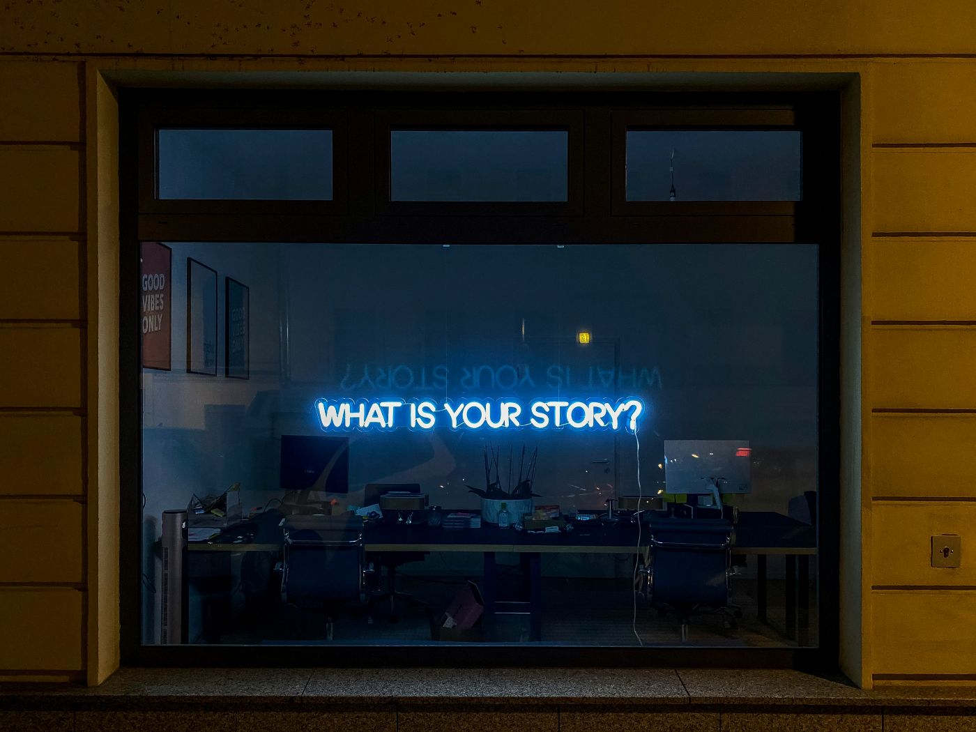 As blue neon light in a window reading what's your story