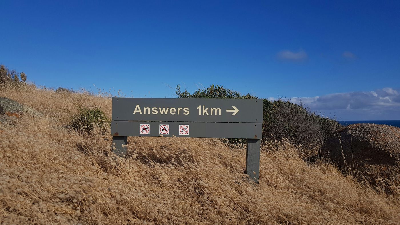 A trail sign that reads: Answers 1KM