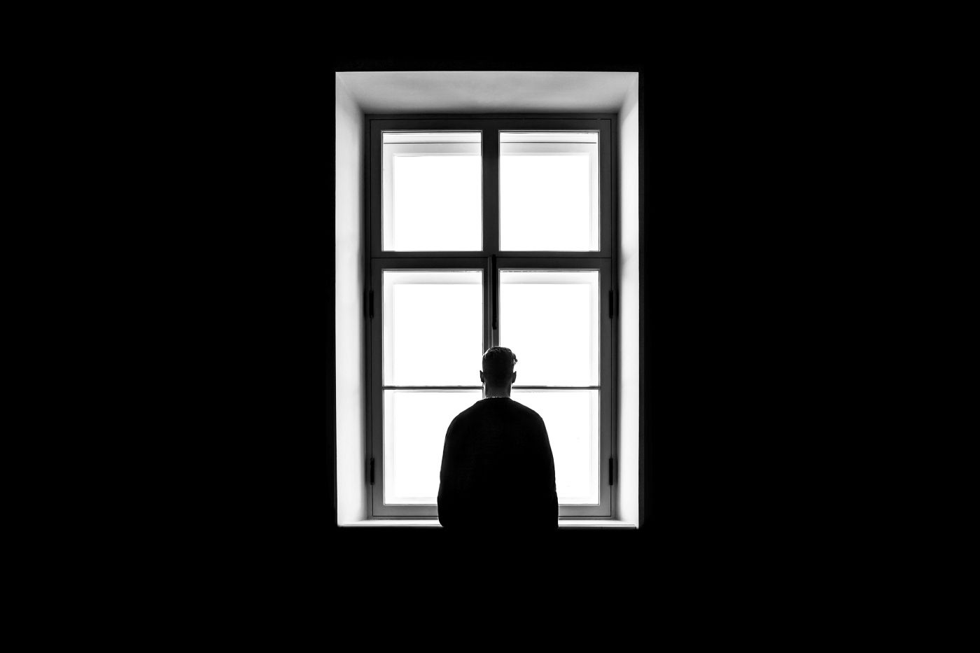 A man standing in front of a mirror with his back to the camera