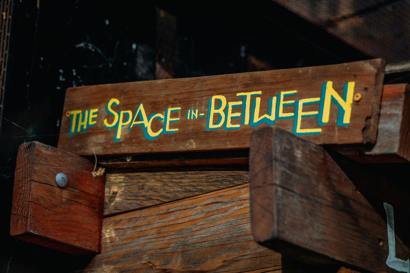 A board with The Space in Between painted on it