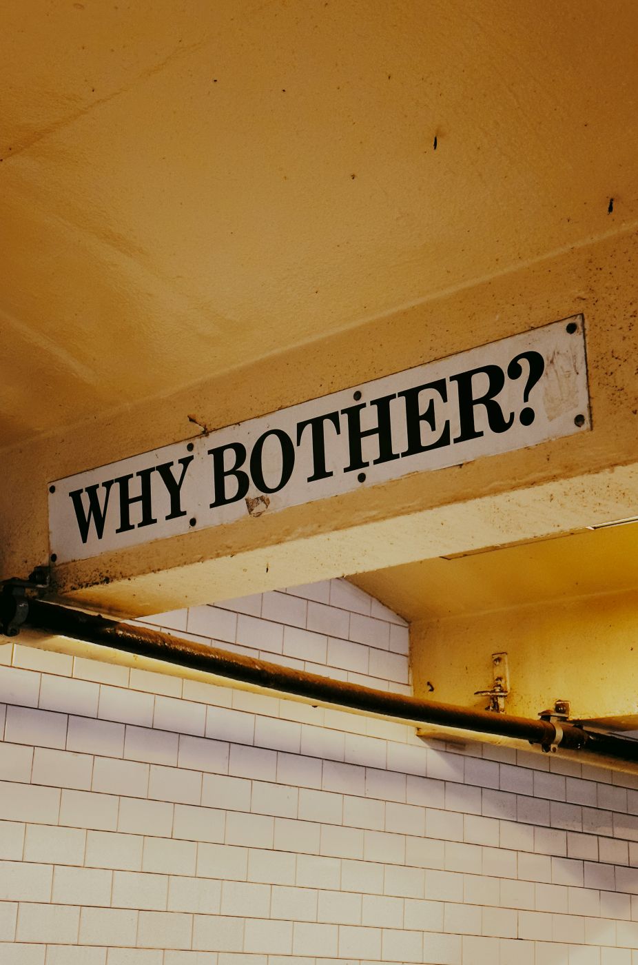 A sign in a subway station reading Why Bother?