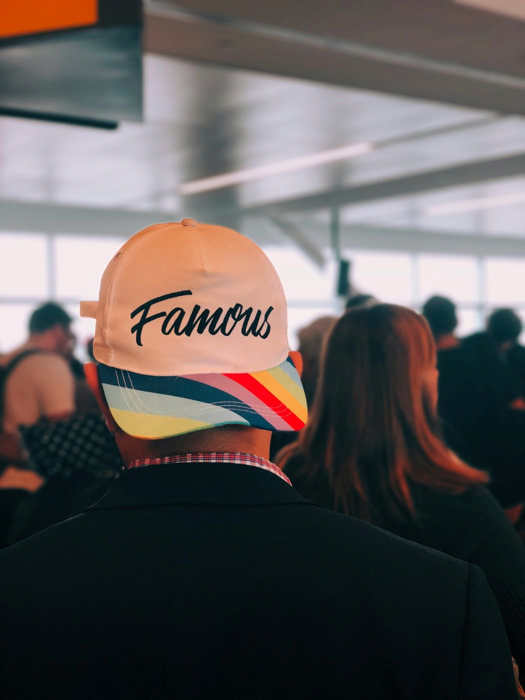 The back of a man wearing a hat that reads Famous