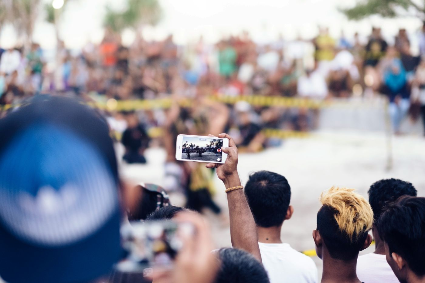 Spectator with his phone up watching and event