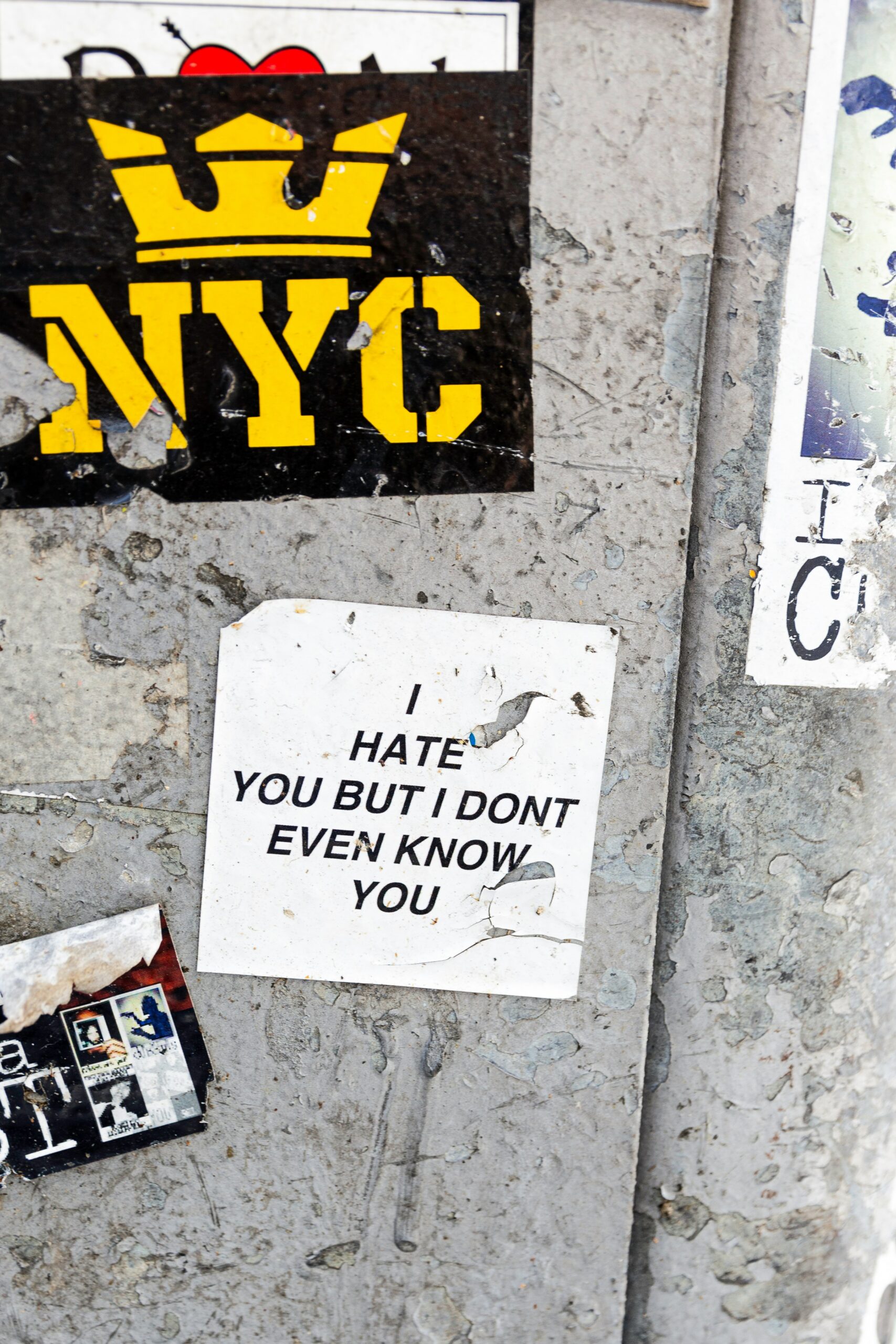 A bill on a concrete wall reading: I hate you, but I don't even know you