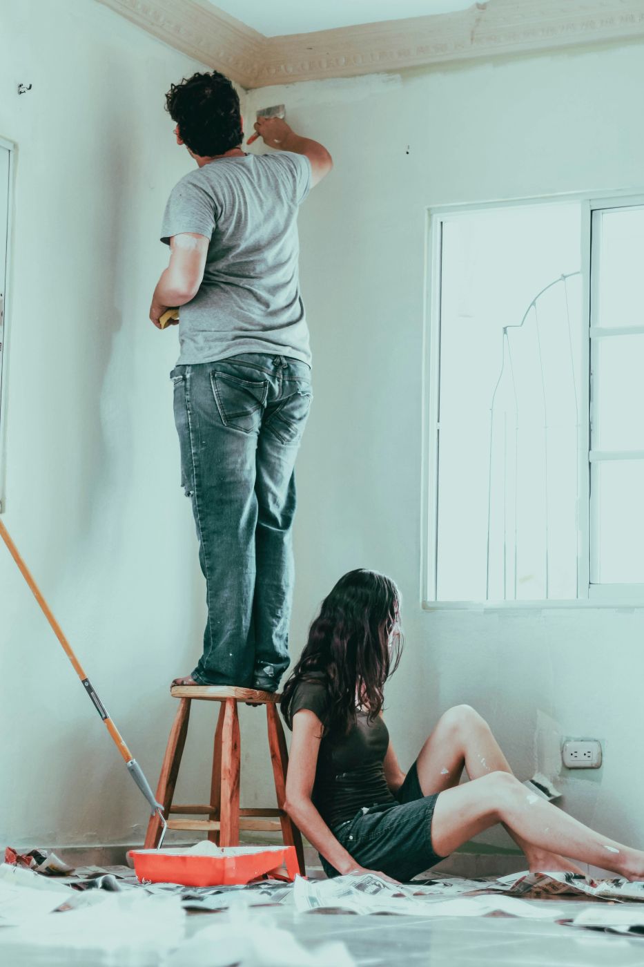 a couple painting the interior of their house