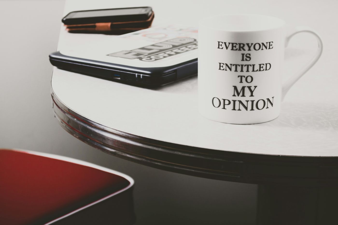 a coffee cup with Everyone is entitled to my opinion on it