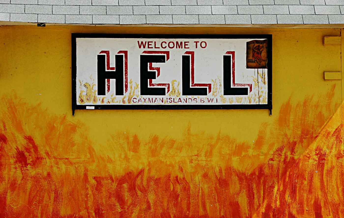 A sign on a wall of painted flames that reads Welcome To Hell