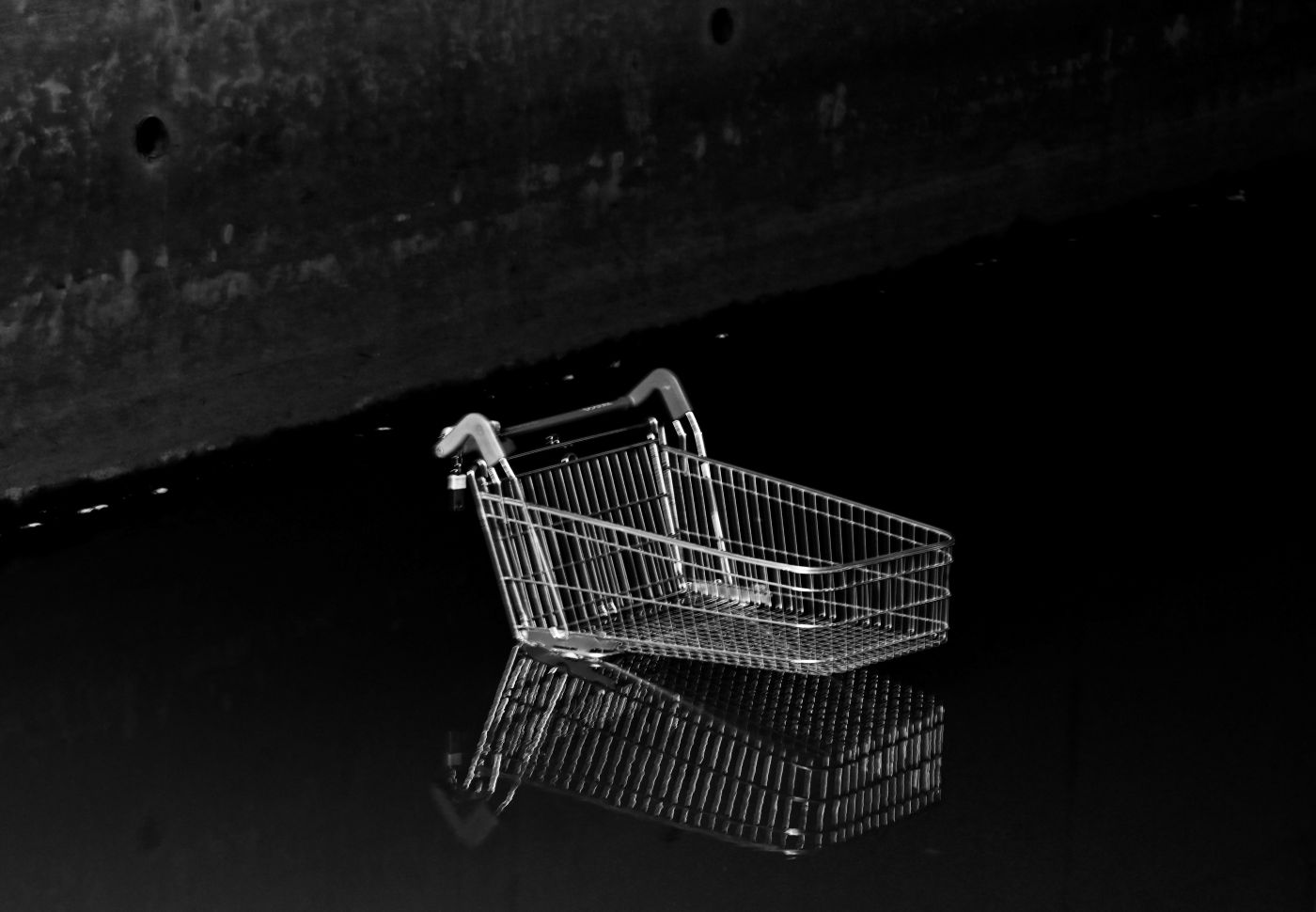 Black and white of a partially submerged shopping cart