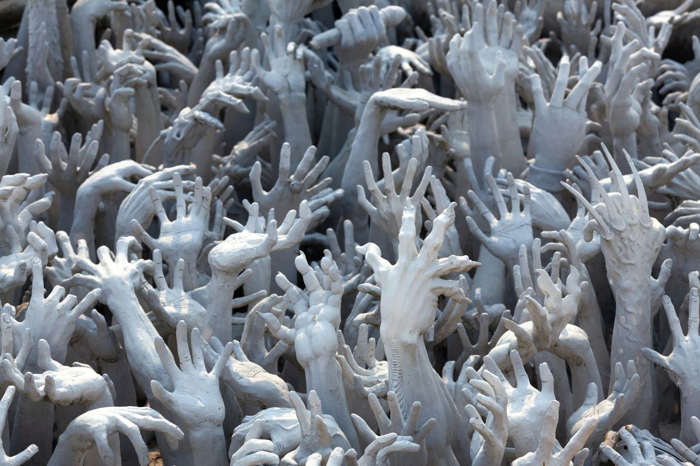 a white sculpture of arms and hands