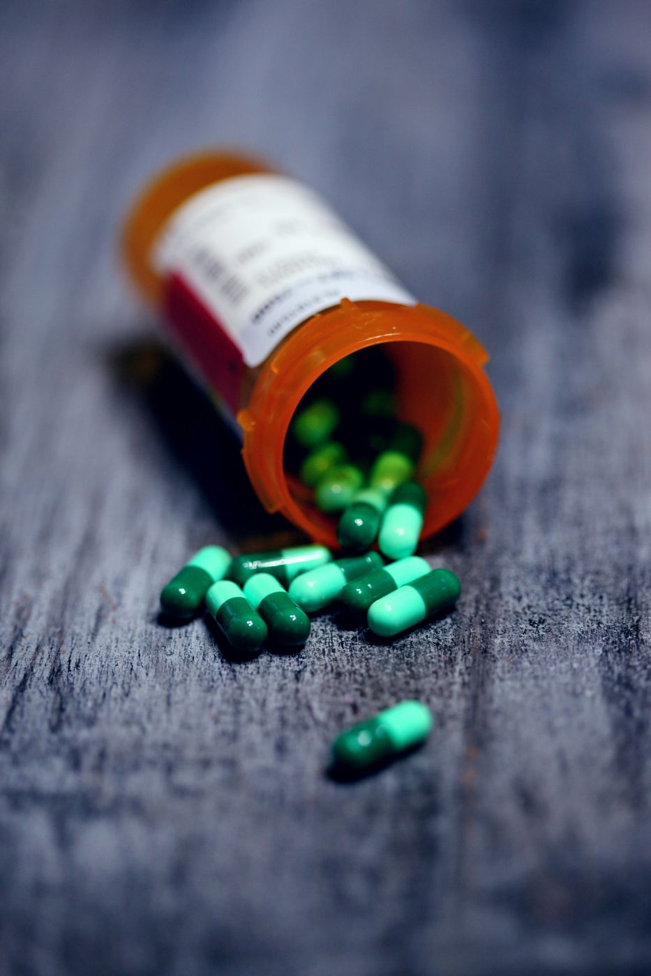 Shallow focus of a prescription bottle and green pills