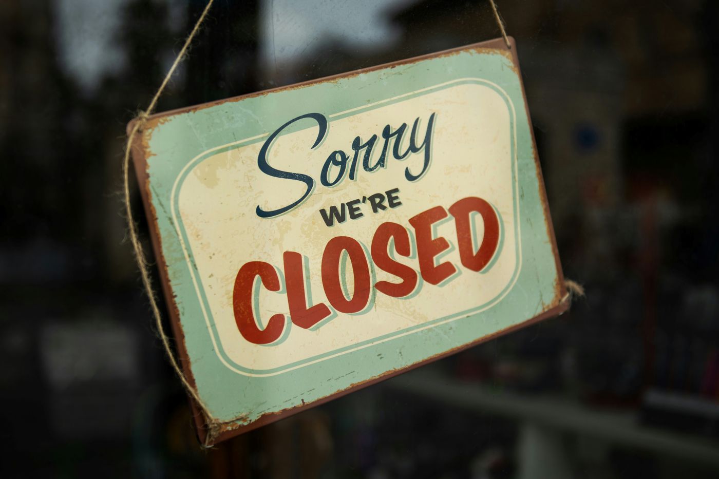 Green and cream sign reading Sorry We're Closed