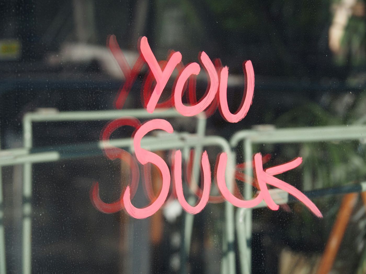 Mirror with You Suck written in pink lipstick